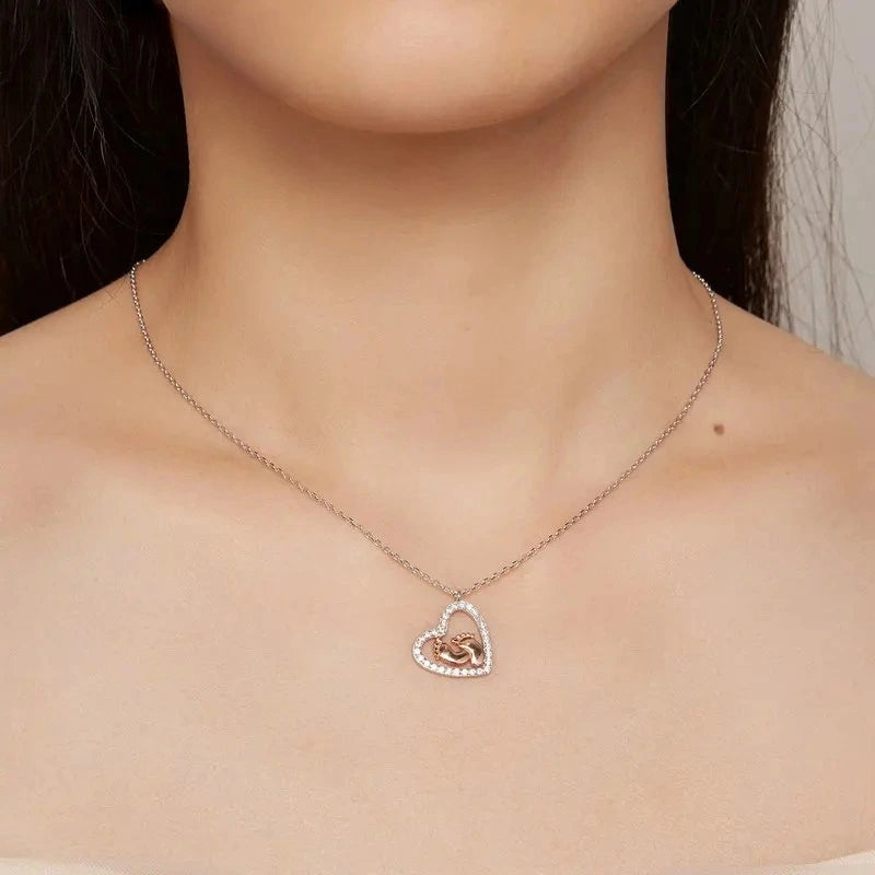 Woman wearing a Footprint Heart sterling silver necklace featuring baby footprint details