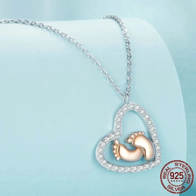 Close-up of a Footprint Heart necklace showcasing pavé stones and rose gold baby footprints