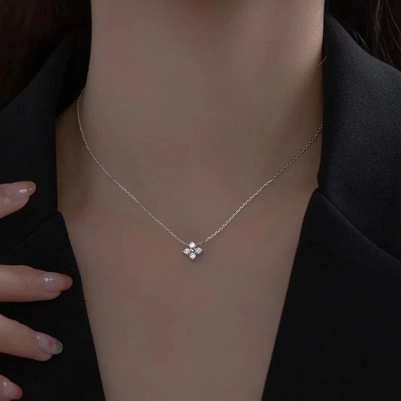 Woman wearing a four leaf clover pendant necklace in 925 sterling silver with brilliant moissanite stones