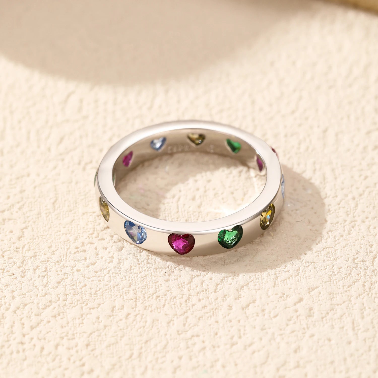 Polished sterling silver band decorated with pink, green, blue and golden hearts