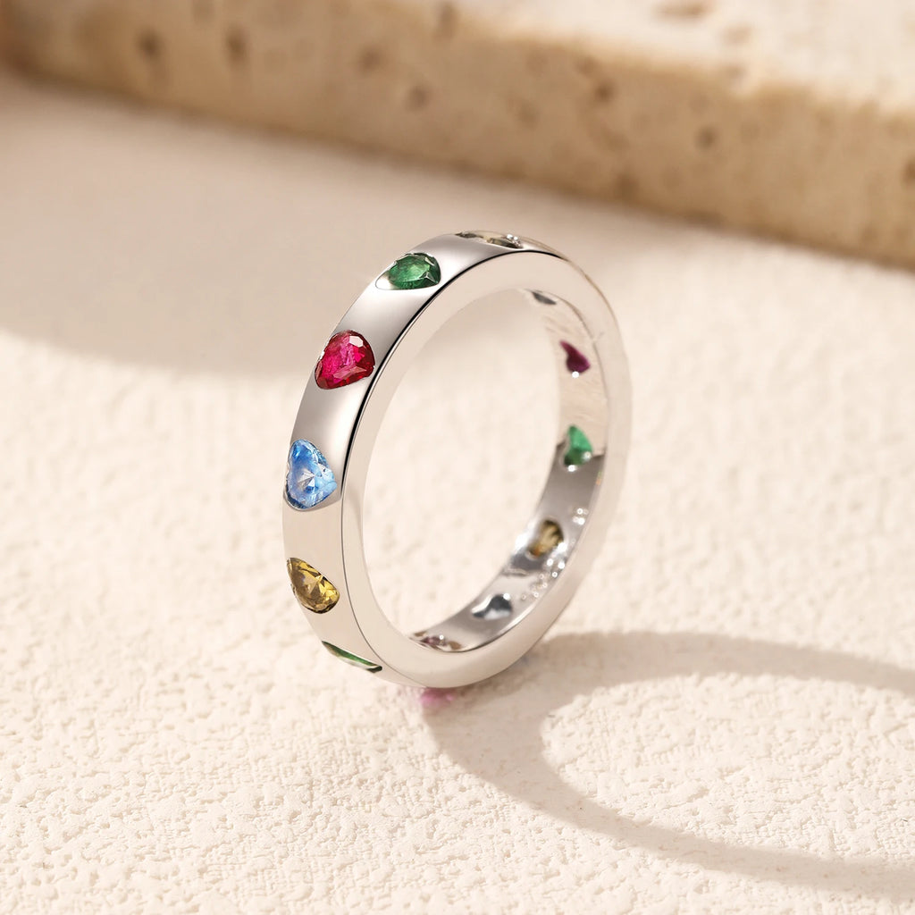 Detailed close-up of colourful heart-shaped cubic zirconia in smooth bezel settings