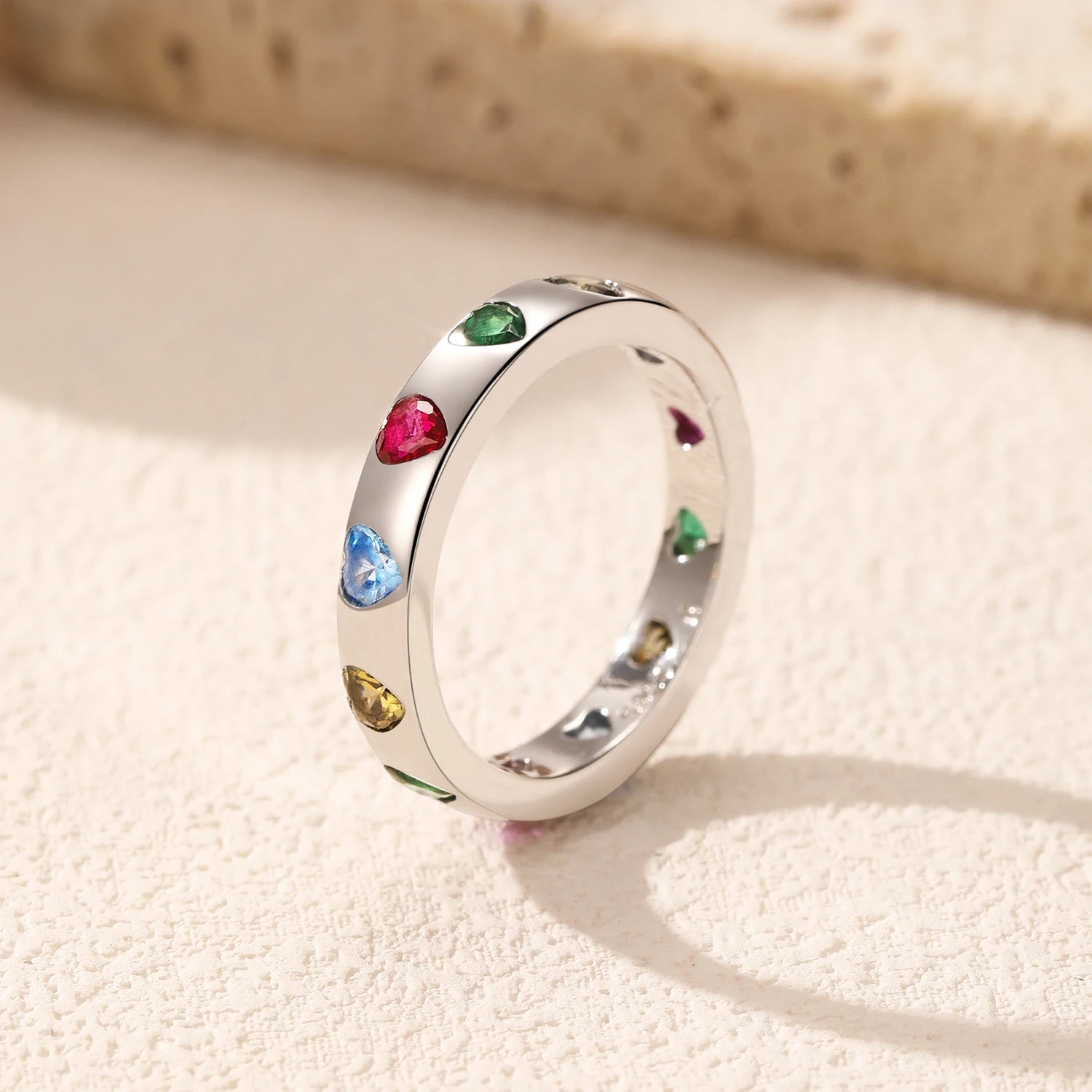 Detailed close-up of colourful heart-shaped cubic zirconia in smooth bezel settings