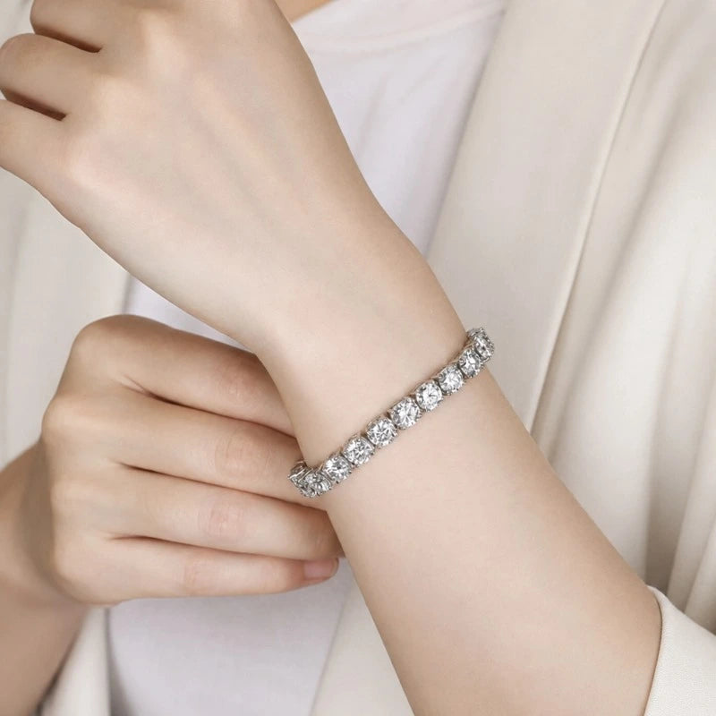 Sterling silver moissanite tennis bracelet worn on a woman's wrist.
