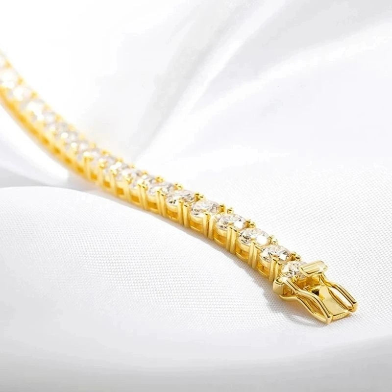 Close-up detail of the clasp and moissanite stone setting on a gold tennis bracelet.