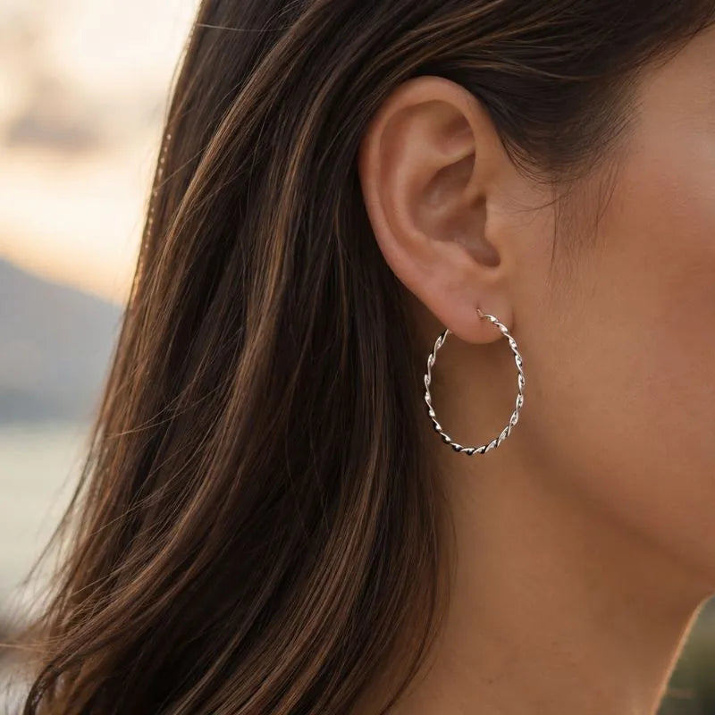 Woman wearing the Aurélie silver twisted hoop earrings