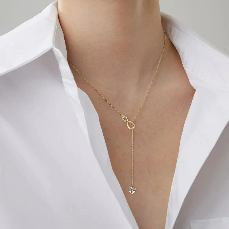 Woman wearing an Gold Infinity Necklace in 925 sterling silver with sparkling moissanite pendant