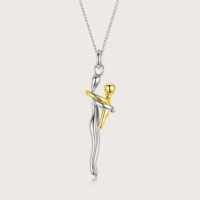 Detailed close-up of the two-tone sterling silver mother and child embrace pendant