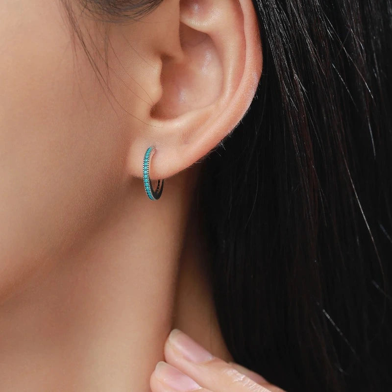 Woman wearing elegant Round Vintage Stud Earrings crafted from genuine 925 sterling silver with natural turquoise stones.