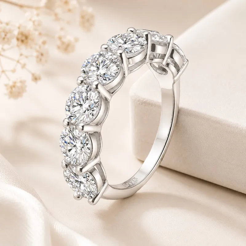 Front view of a sterling silver moissanite eternity ring with round brilliant stones.