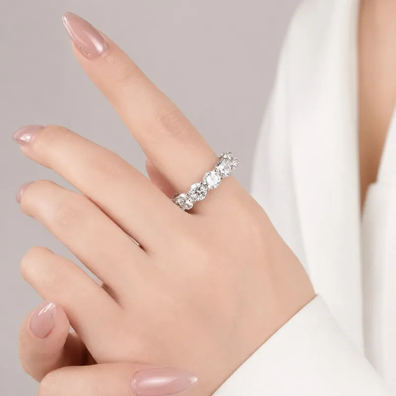 Woman wearing a sterling silver moissanite eternity ring.