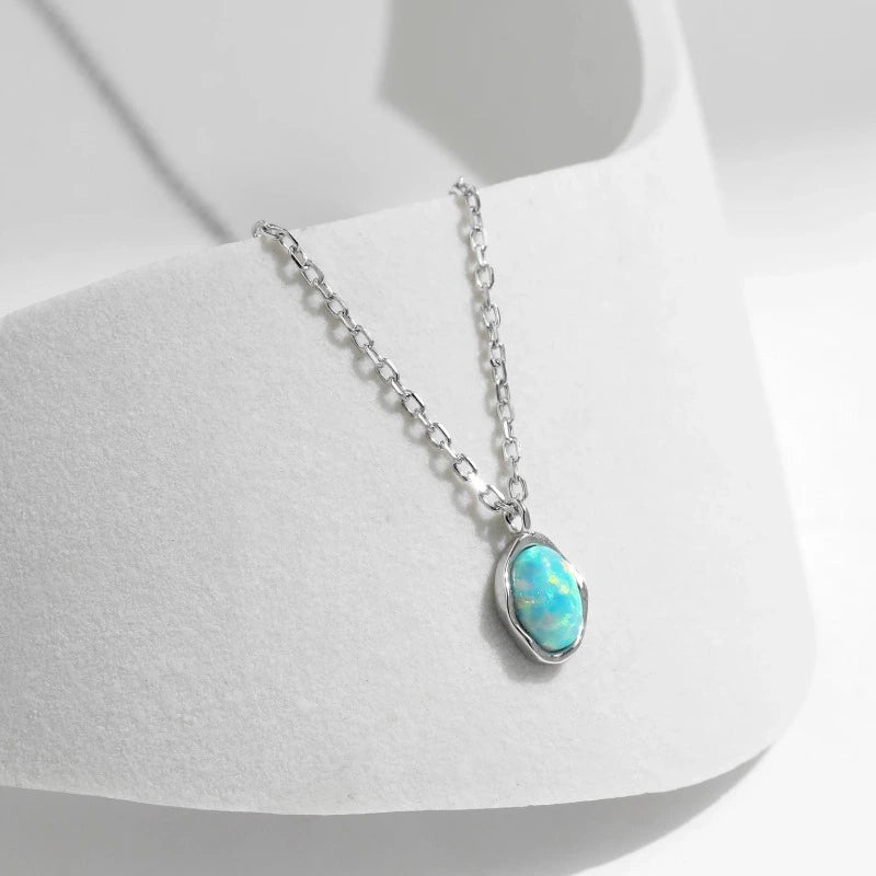 Sterling silver opal pendant necklace with an oval solitaire stone and minimalist polished setting