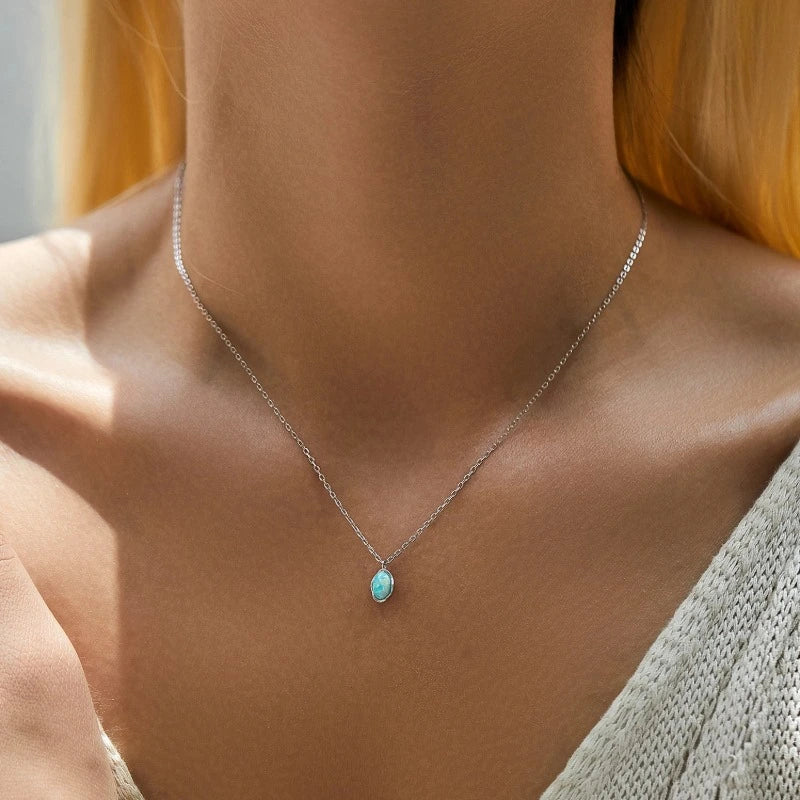 Woman wearing a 925 Sterling Silver Opal Pendant Necklace with a small iridescent oval pendant